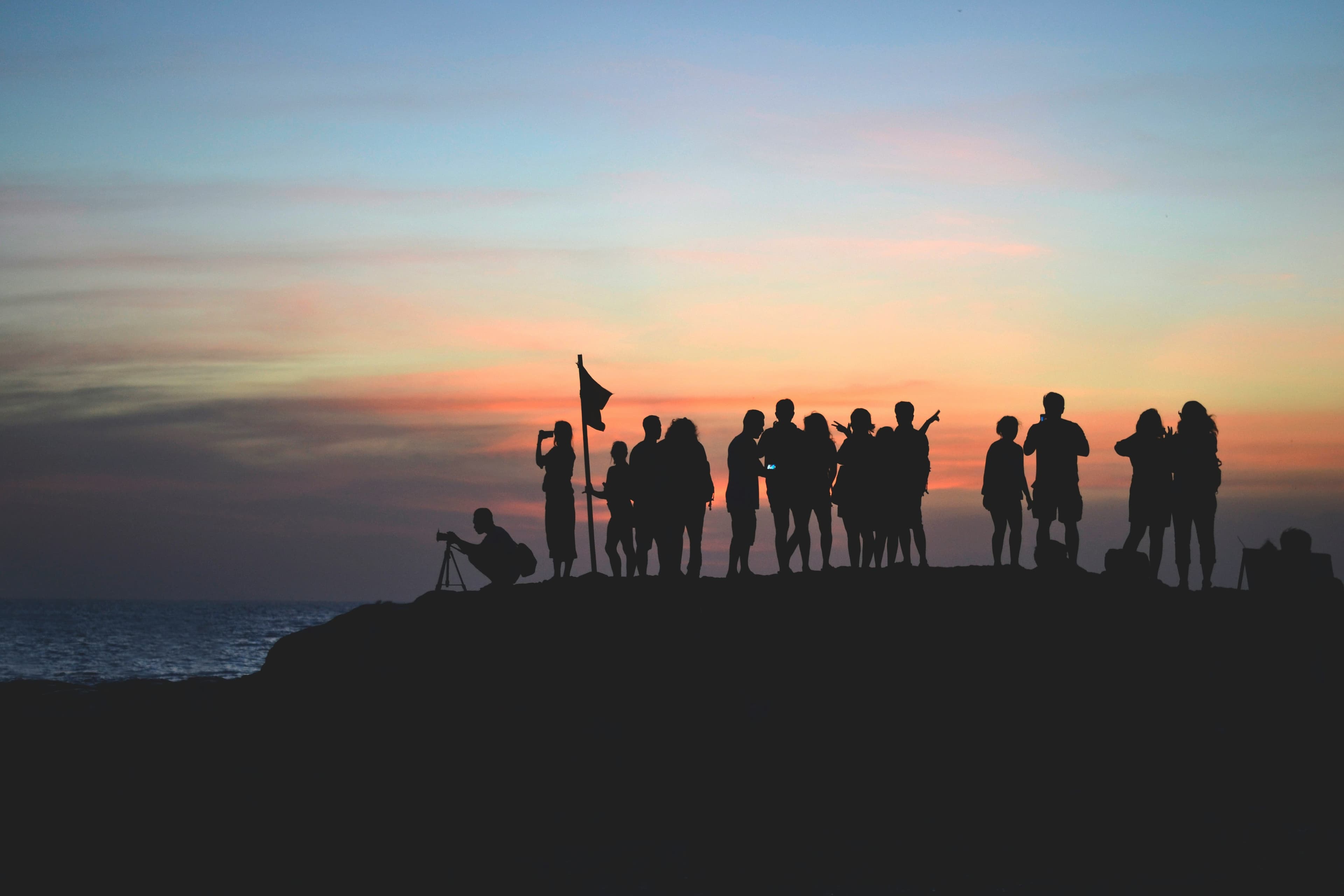 Sunset scene with people silhouetted against colorful sky